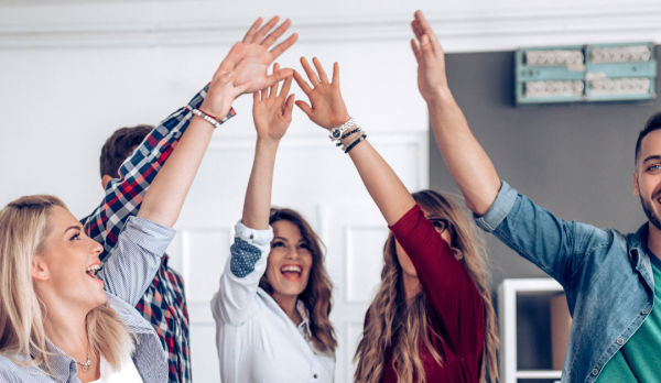 A picture of people raising their hands together