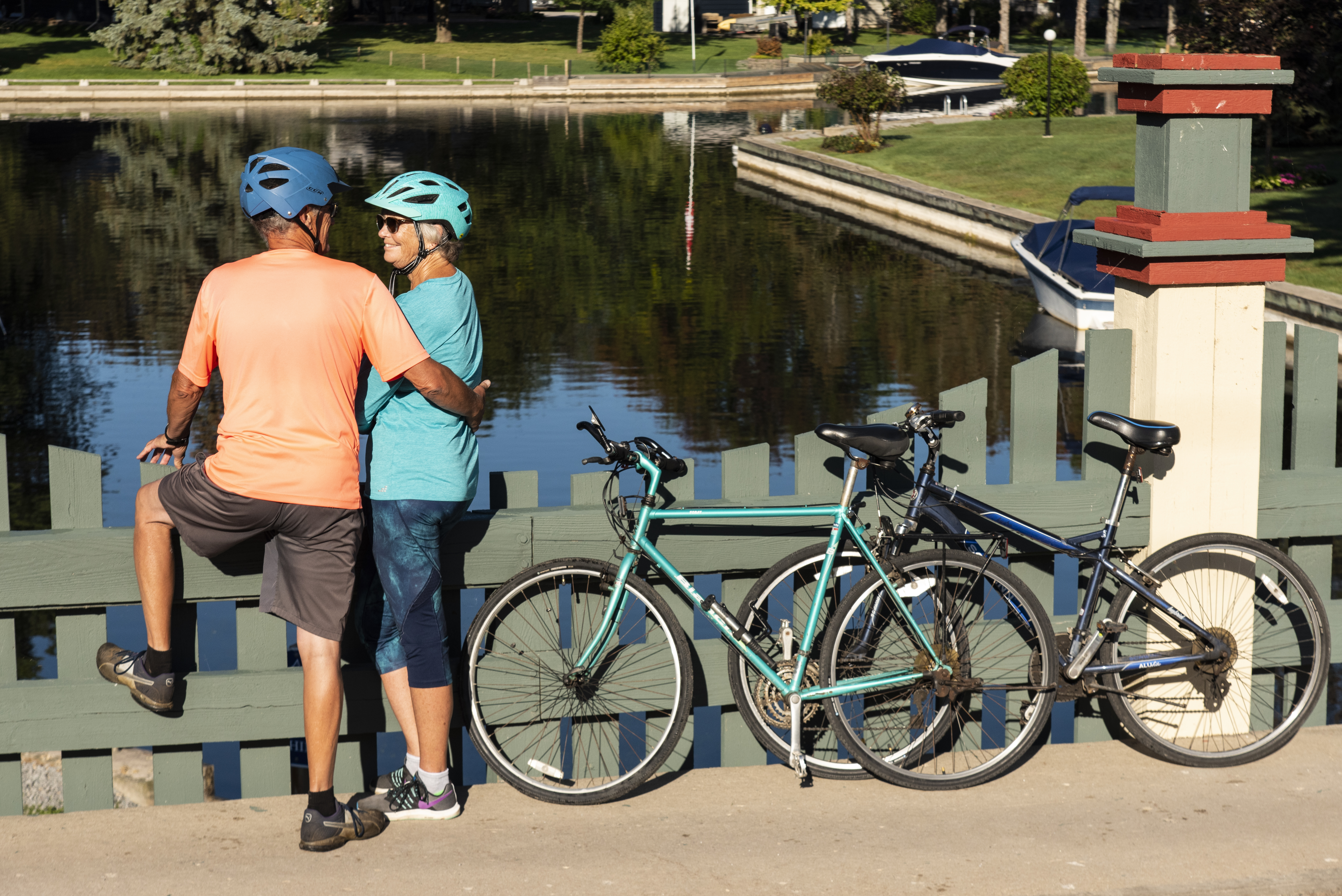 A picture of a couple standing on a bridge with their bikes