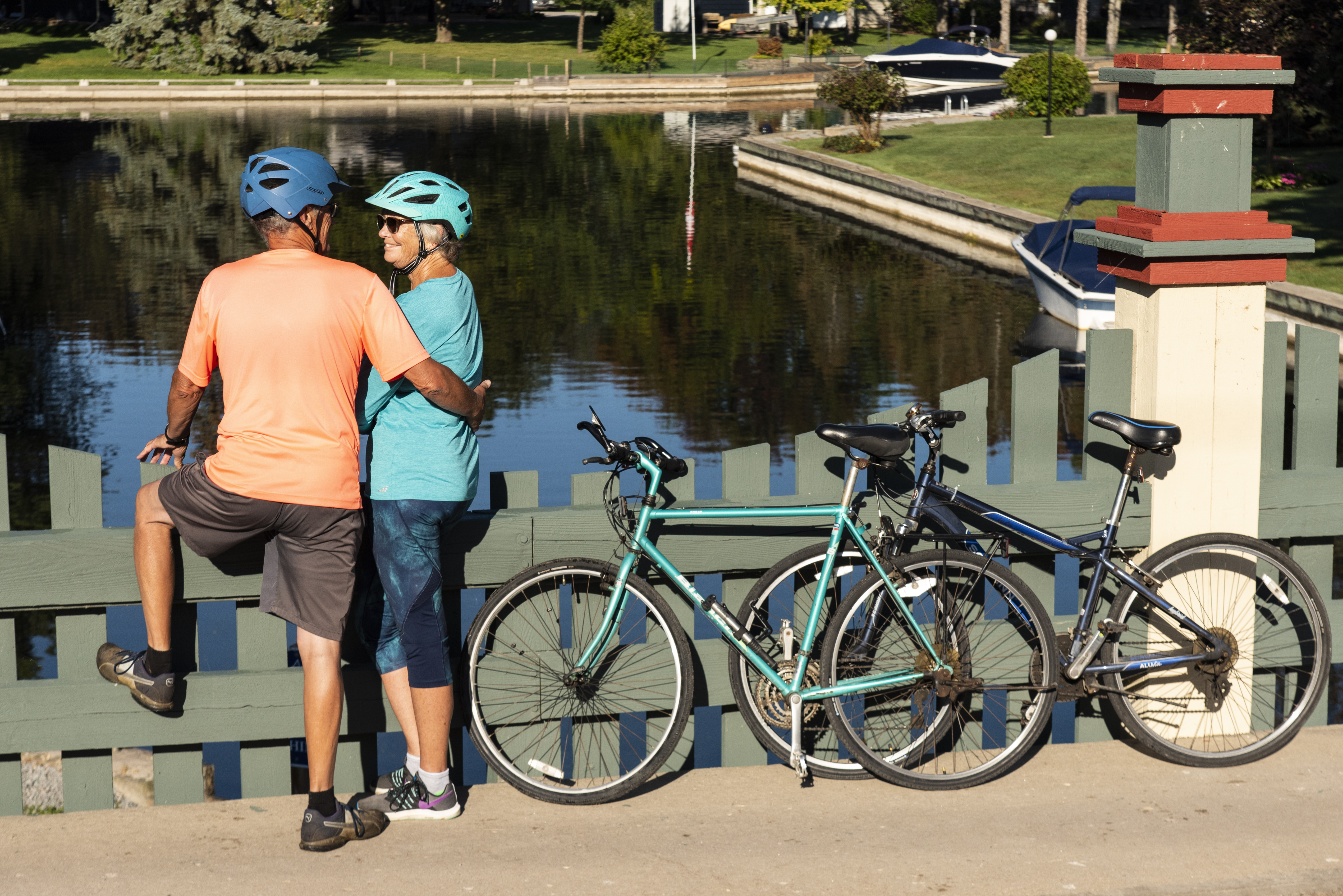 Two people holding their bikes