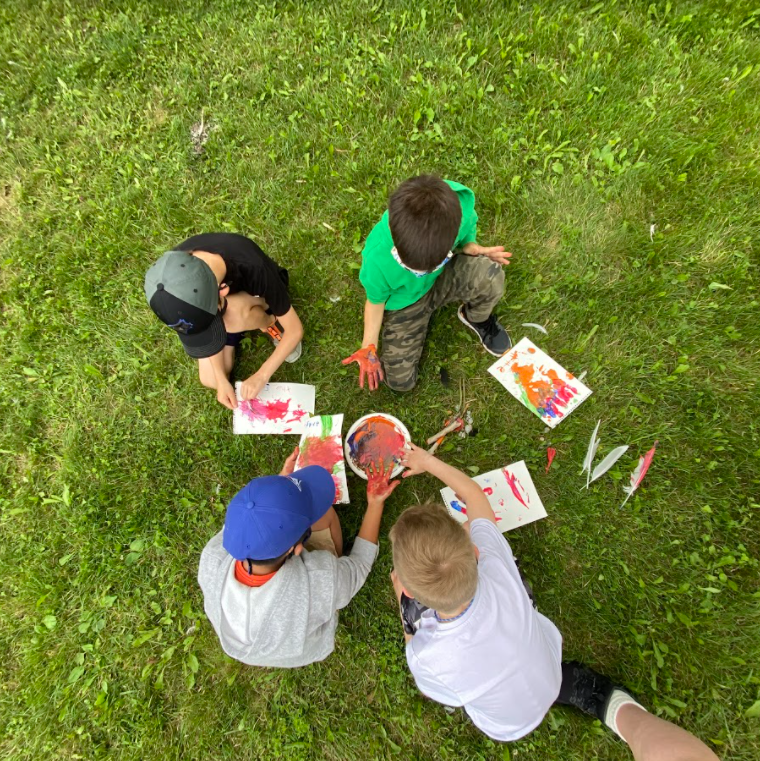 four children finger painting outside