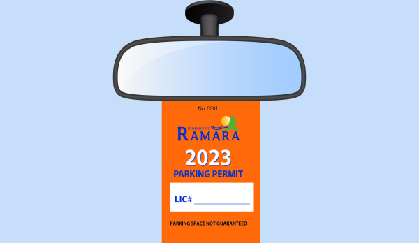 Picture of a car's rear view mirror with 2023 Parking permit hanging from it 