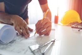 Man writing on building plans