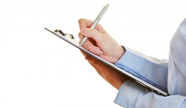Picture of a man holding a metal clip board with a pen
