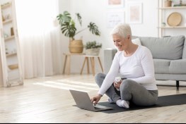 Woman later in age on the floor turning on Computer